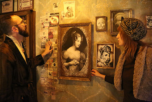 Man and woman looking for clues in wall art in the Inventor's Attic